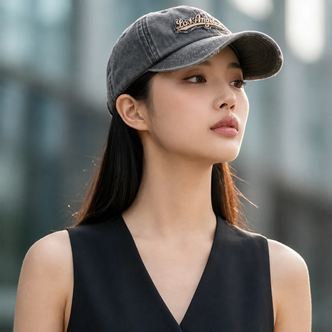도심에서 태가 볼캡을 쓴 여성의 옆모습